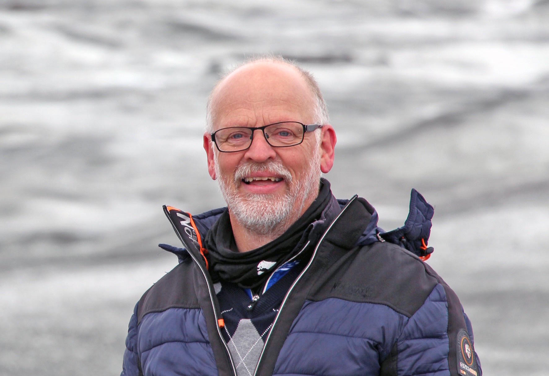 A person in a jacket against an icy backdrop